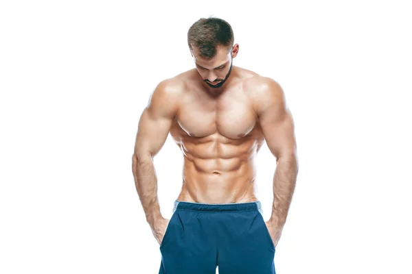 Bodybuilder poseren. Mooie sportieve vent mannelijke kracht. Fitness gespierd in blauwe shorts. op geïsoleerde witte achtergrond. Man met gespierde torso. Sterke atletische Man Fitness Model Torso weergegeven: zes pack abs — Stockfoto