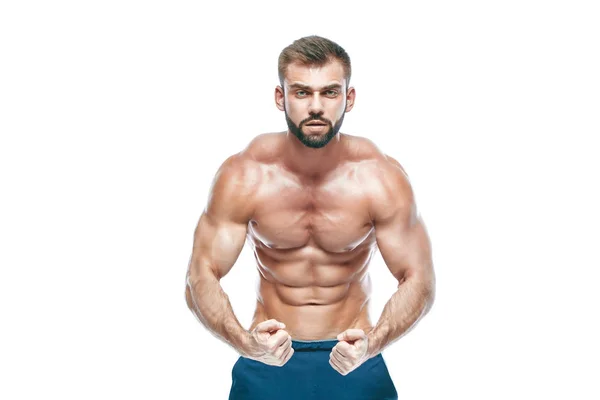 Bodybuilder posa. Bellissimo ragazzo sportivo potere maschile. Fitness muscoloso in pantaloncini blu. su sfondo bianco isolato. Uomo con il busto muscoloso. Forte atletica uomo fitness modello busto mostrando sei pack abs — Foto Stock