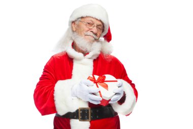 Noel. Noel Baba beyaz eldiven gülümseyen bir kırmızı ve beyaz kalp şeklinde hediye kutu kırmızı kurdele ile tutar. Beyaz arka plan üzerinde izole.
