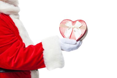 Noel. Noel Baba beyaz eldiven bir kırmızı kalp şeklinde hediye kutusu beyaz bir kurdele ile tutar. Beyaz arka plan üzerinde izole. Yakın çekim