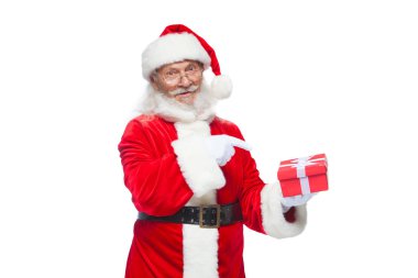 Noel. Noel Baba beyaz eldiven gülümseyen bir hediye kırmızı kutusu bir yay ile tutuyor. Hediyesine işaret. Beyaz arka plan üzerinde izole.
