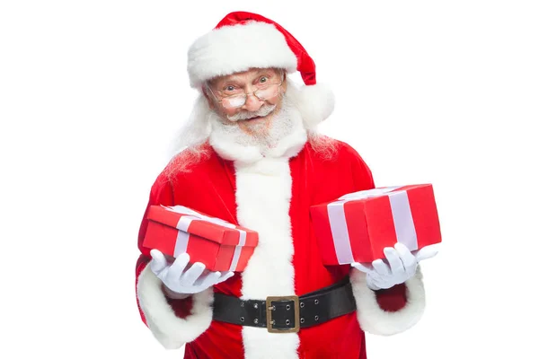 Navidad. Santa Claus sonriente con guantes blancos sostiene dos cajas con regalos. El concepto de elegir un regalo, regalos generosos. Aislado sobre fondo blanco . —  Fotos de Stock