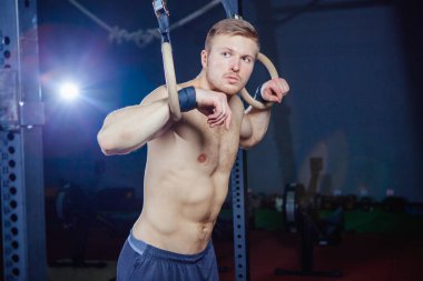 Kaslı adam Yüzüklerin stil uygun çapraz üzerinde egzersiz yaparak