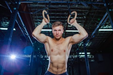 Kaslı adam Yüzüklerin stil uygun çapraz üzerinde egzersiz yaparak