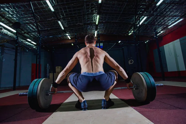 Mięśni fitness człowiek przygotowuje się do martwy sztangą nad głową w nowoczesnym centrum fitness. Trening funkcjonalny. Ćwiczenia wyrwać. — Zdjęcie stockowe