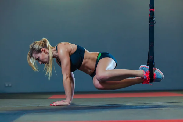 Mulher desportiva fazendo exercícios TRX no ginásio — Fotografia de Stock