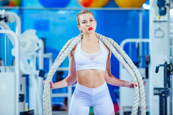 健身妇女与战斗绳索在健身房锻炼。在相机上摆姿势 — 图库照片