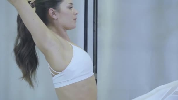 ピラティス。改質器のジムでのストレッチ運動を練習して白い服の女性。番号 01234567890001 ですべてのシリーズ. — ストック動画