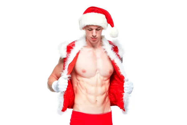 Sexy Santa Claus. Un joven musculoso con sombrero de Santa Claus demuestra sus músculos. Aislado sobre fondo blanco. —  Fotos de Stock