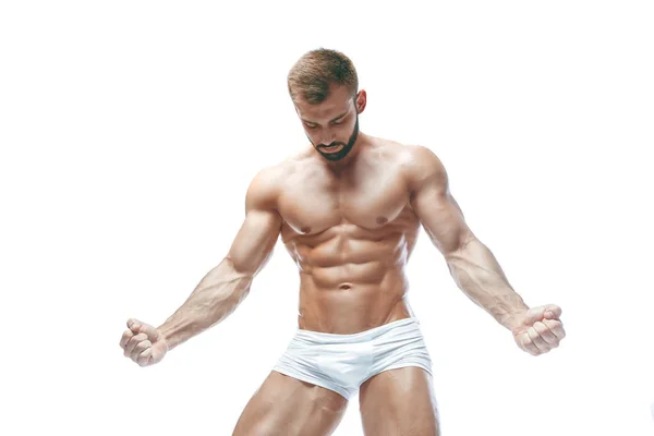 Kroppsbyggare poserar. Vacker sportig kille manlig makt. Konditionen muskulös manin vita underkläder. på isolerade vit bakgrund. — Stockfoto