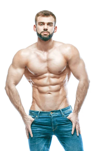 Bodybuilder poseren. Mooie sportieve vent mannelijke kracht. Fitness gespierd in spijkerbroek. op geïsoleerde witte achtergrond. — Stockfoto