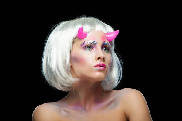 Dia das Bruxas. Retrato de menina bonita jovem com maquiagem. Com cabelos brancos e chifres cor-de-rosa. Isolado em fundo preto . — Fotografia de Stock