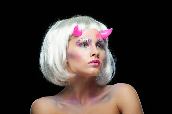 Halloween. Porträtt av ung vacker flicka med make-up. Med vitt hår och rosa djävulshorn. Isolerad på svart bakgrund. — Stockfoto