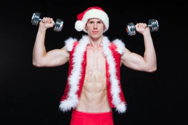 Tatiller ve kutlamalar, yeni yıl, yılbaşı, spor, vücut geliştirme, sağlıklı yaşam - kas yakışıklı Noel Baba. siyah bir arka plan üzerinde dumbbells ile. Beyaz arka plan üzerinde izole.