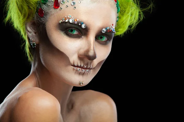 Halloween. Portrait de jeune belle fille avec squelette maquillé sur son visage. Et les cheveux verts. Isolé sur fond noir . — Photo