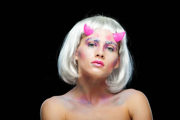 Halloween. Porträtt av ung vacker flicka med make-up. Med vitt hår och rosa djävulshorn. Isolerad på svart bakgrund. — Stockfoto