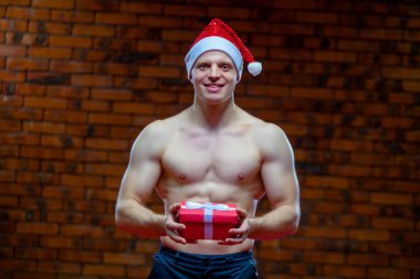 Noel Baba. Fitness Noel Baba bir tuğla duvar arka plan üzerinde izole. Seksi fitness Noel Baba. Kas Noel Baba ile giftboxes