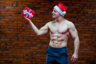 Noel Baba. Fitness Noel Baba bir tuğla duvar arka plan üzerinde izole. Seksi fitness Noel Baba. Kas Noel Baba ile giftboxes
