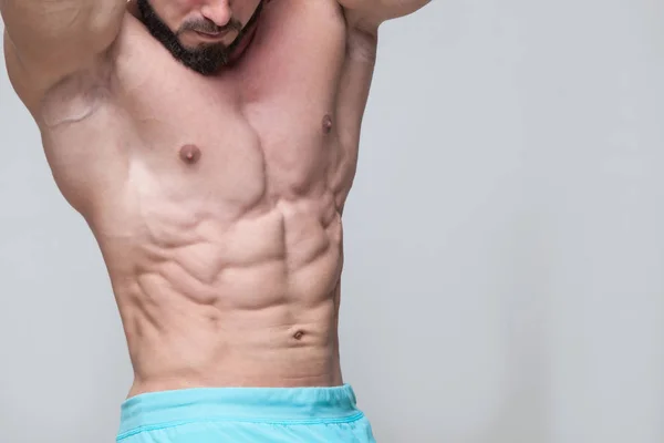 Starker athletischer Mann Fitness-Modell Oberkörper zeigt Sixpack Bauchmuskeln. isoliert auf grauem Hintergrund mit Copyspace — Stockfoto