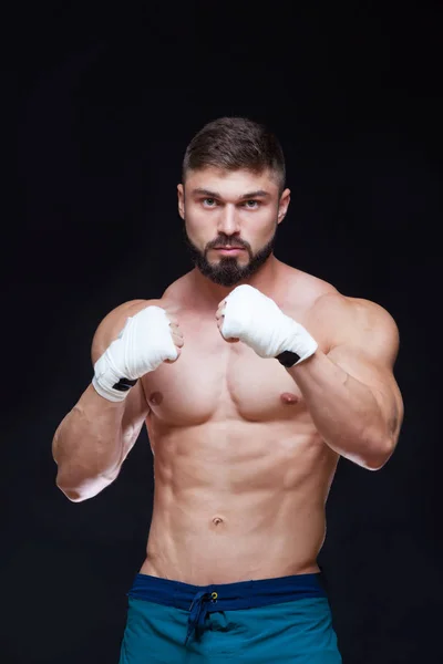 Muscular Fighter kickbox con vendajes blancos contra el fondo negro . —  Fotos de Stock