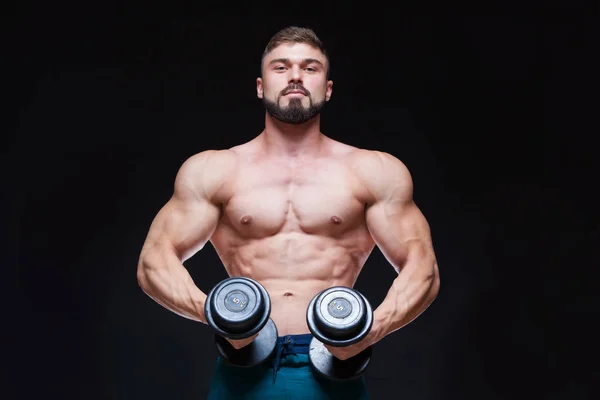 Muskulöser Bodybuilder, der Übungen mit Hantel vor schwarzem Hintergrund macht — Stockfoto