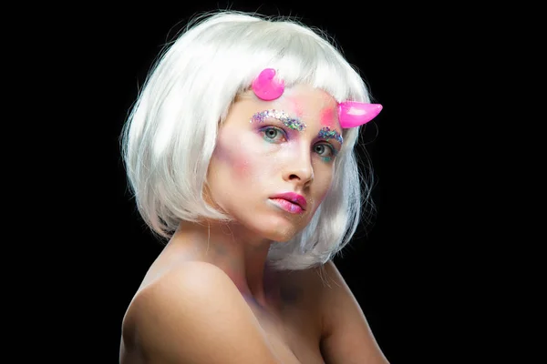 Halloween. Portrait of young beautiful girl with make-up. With white hair and pink devil horns. Isolated on black background. — Stock Photo, Image