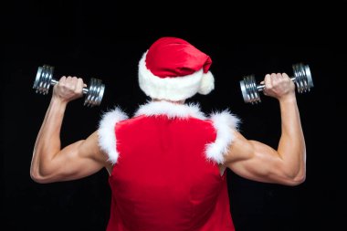 Tatiller ve kutlamalar, yeni yıl, yılbaşı, spor, vücut geliştirme, sağlıklı yaşam - kas yakışıklı Noel Baba. siyah bir arka plan üzerinde dumbbells ile. Beyaz arka plan üzerinde izole.