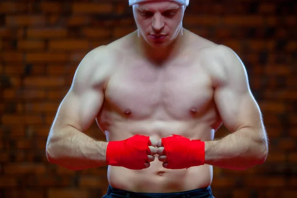 圣诞节。肌肉战斗机 kickbox 拳击圣诞老人用红色绷带墙的背景. — 图库照片
