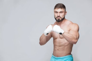 Gri arka planı beyaz bandaj ile kaslı savaşçı kickbox