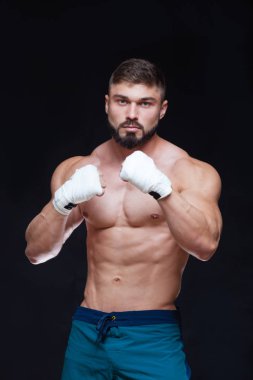 Siyah arka plan beyaz bandaj ile kaslı savaşçı kickbox.
