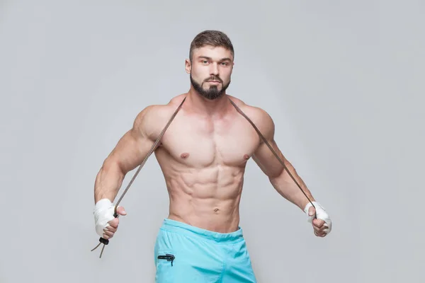 Sport, aktivitet. Muskulös Fighter kickbox med hopprep. Muskulösa män grå bakgrund. — Stockfoto