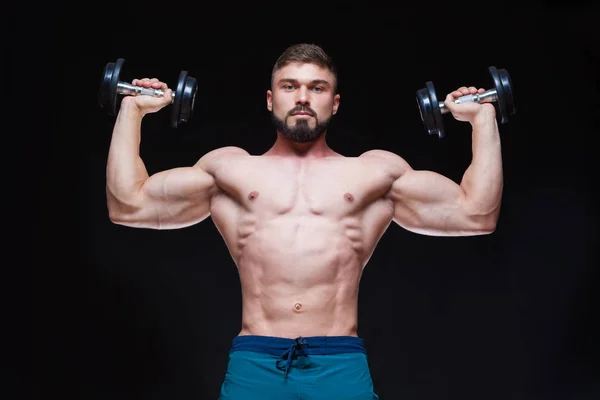 Muskulöser Bodybuilder, der Übungen mit Hantel vor schwarzem Hintergrund macht — Stockfoto