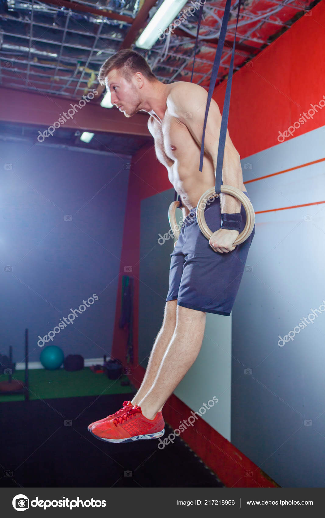 Muscleup exercise young man doing intense cross fit workout at the gym
