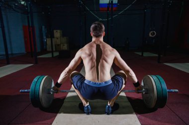 Kas fitness adam başını modern fitness merkezinde bir halter Deadlift için hazırlanıyor. Fonksiyonel eğitim. Egzersiz kapmak.