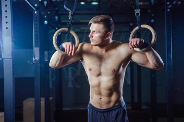 Kaslı adam Yüzüklerin stil uygun çapraz üzerinde egzersiz yaparak