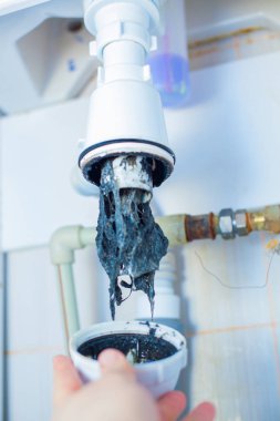 Tıkanmış Lavabo boru. Bir drenaj kıllar ve diğer şeyler unclog. Banyodaki lavabonun altında drenaj su için hidrolik tuzak kontrol. Hidrolik sorunları, sızdıran musluk ile ilgili eserler.