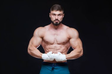 Siyah arka plan beyaz bandaj ile kaslı savaşçı kickbox.