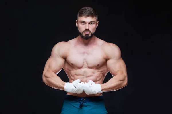 Kickbox combattente muscolare con fasciature bianche contro lo sfondo nero . — Foto Stock