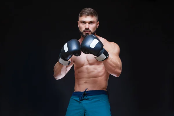 Silnych mięśni bokser w czarne rękawice bokserskie. Na białym na czarnym tle. — Zdjęcie stockowe