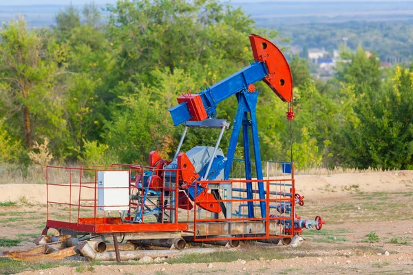 La pompa dell'olio, attrezzature industriali. Sito del giacimento petrolifero, le pompe dell'olio sono in funzione. Macchine a dondolo per la produzione di petrolio in un settore privato . — Foto Stock