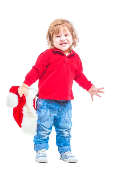 Vánoce. Chlapeček v Santa čepice v červené bundě a modré džíny. Izolované na bílém pozadí. — Stock fotografie