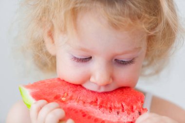 sevimli küçük bebek kız üzerinde açık renkli karpuz dilimi yemek