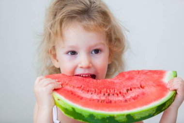 sevimli küçük bebek kız üzerinde açık renkli karpuz dilimi yemek.