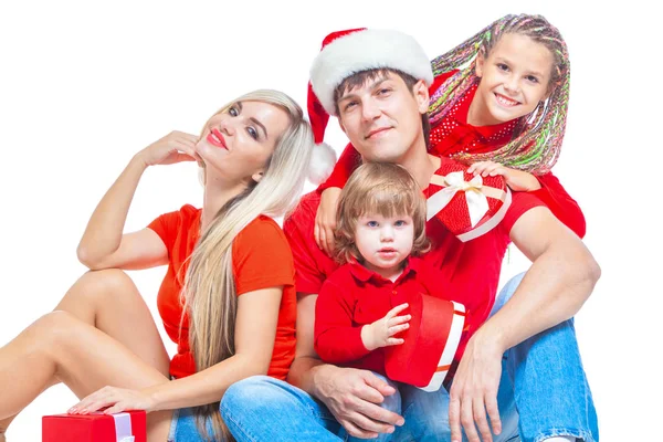 Familia en Navidad. Familia alegre en los sombreros de Santa mirando a la cámara y sonriendo mientras está aislado en blanco. Familia amante del retrato de cerca . — Foto de Stock