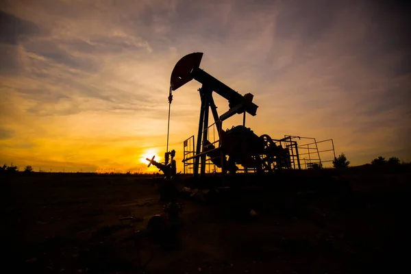 À noite, o esboço. A bomba de óleo, equipamento industrial. Local de campo, bombas de óleo estão funcionando. Máquinas de baloiçar para a produção de petróleo num sector privado . — Fotografia de Stock