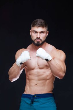 Siyah arka plan beyaz bandaj ile kaslı savaşçı kickbox.