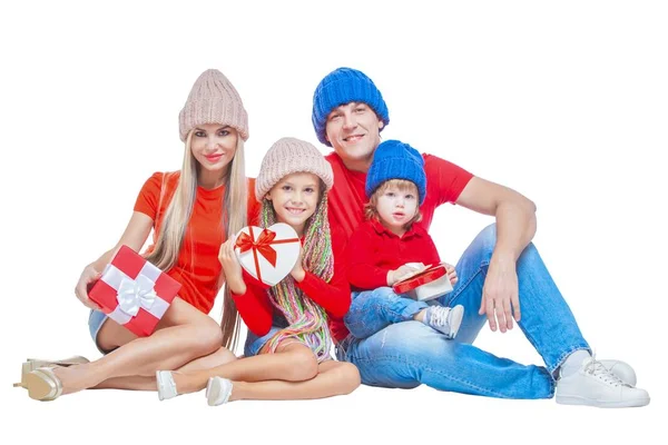 Семья на Рождество. Веселая семья в шляпах смотрит в камеру и улыбается, находясь в изоляции на белом. Подарочные коробки в руке. Портретная любящая семья . — стоковое фото