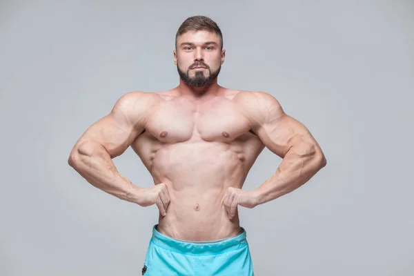 Sterke atletische Man Fitness Model Torso weergegeven: sixpack abs. geïsoleerd op grijze achtergrond met copyspace — Stockfoto