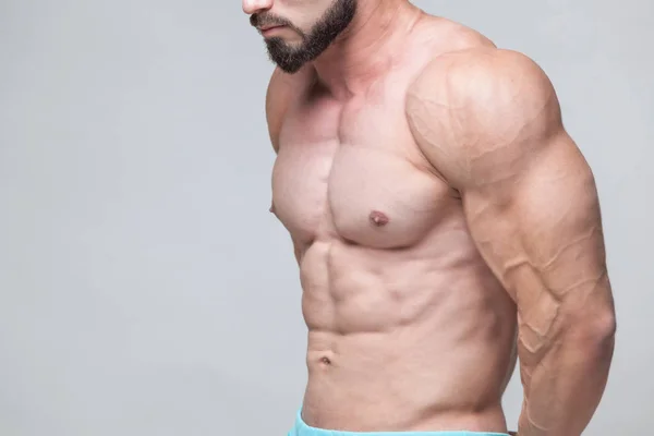 Starker athletischer Mann Fitness-Modell Oberkörper zeigt Sixpack Bauchmuskeln. isoliert auf grauem Hintergrund mit Copyspace — Stockfoto