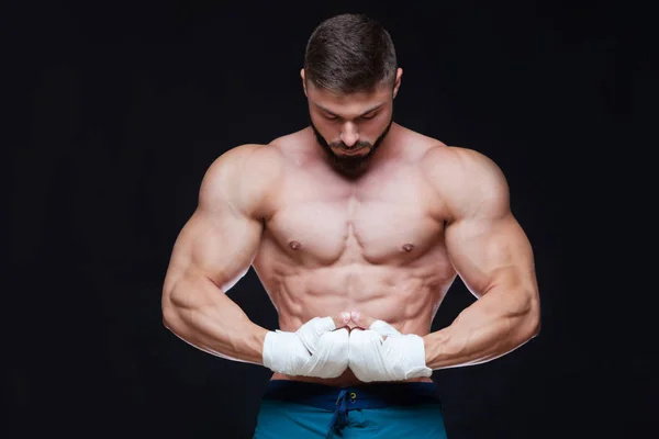 Muskulös Fighter kickbox med vitt bandage mot svart bakgrund. — Stockfoto